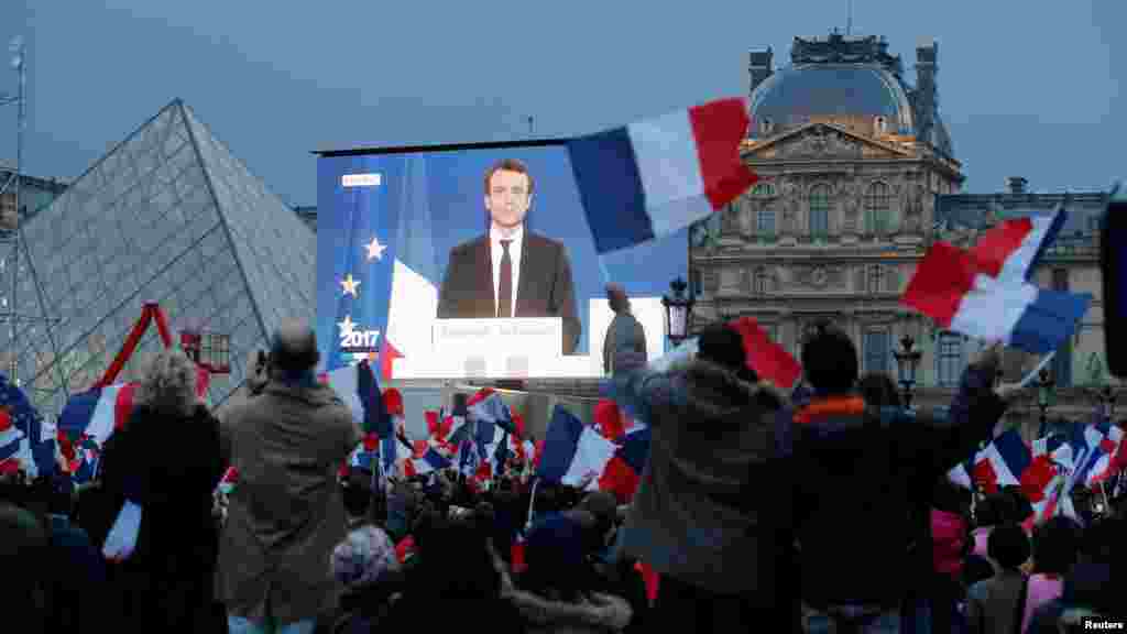 投票结果公布后，巴黎卢浮宫附近的大型屏幕上显示当选总统马克龙（2017年5月7日）。39岁的马克龙将是法兰西第五共和国近60年历史上最年轻的总统。