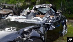 FILE - In this photo provided by the National Transportation Safety Board via the Florida Highway Patrol, a Tesla Model S that was being driven by Joshua Brown, who was killed when the Tesla sedan crashed while in self-driving mode on May 7, 2016.