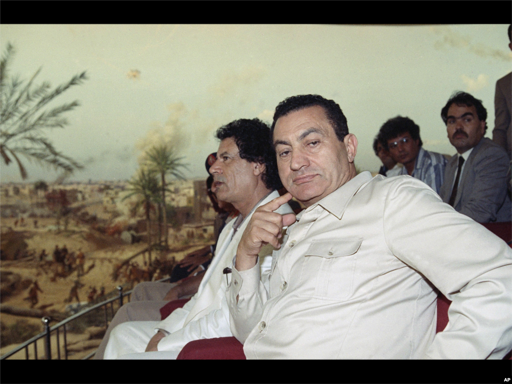 (美联社) 在1990年六月一号，利比亚领导人卡扎菲与埃及总统穆巴拉克在开罗参观1973年阿拉伯-以色列战争的图片及武器展览