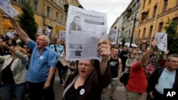 Activists hold leaflets reading 'In Support of Navalny' with a photo of opposition leader Alexei Navalny who was convicted of embezzlement and sentenced to five years in prison, in St. Petersburg, Russia, July 18, 2013.