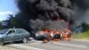 Two police cars ablaze at the site of unrest in Mukhachevo, Western Ukraine, July 11, 2015.