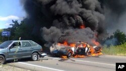 Two police cars ablaze at the site of unrest in Mukhachevo, Western Ukraine, July 11, 2015.