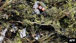 Fotografía difundida por la oficina de prensa de la Fuerza Aérea Colombiana muestra a miembros de la Fuerza Aérea junto a los restos de una aeronave que se estrelló en una zona rural de Urrao, provincia de Antioquia, Colombia, el 10 de enero de 2025.