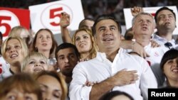 Georgia's President and leader of the ruling United National Movement party Mikheil Saakashvili gestures during the national anthem with his supporters during an election rally at a stadium in Tbilisi September 28, 2012. REUTERS/David Mdzinarishvili (GEOR