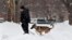 A Secret Service K-9 unit does a security sweep in the falling snow in Lafayette Park across from the White House in Washington, Feb. 13, 2014.