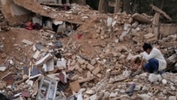 Lina Rida Jawhari menangis saat duduk di reruntuhan rumah keluarganya yang hancur di Baalbek, Lebanon timur, Kamis, 28 November 2024. (/Hassan Ammar/AP)