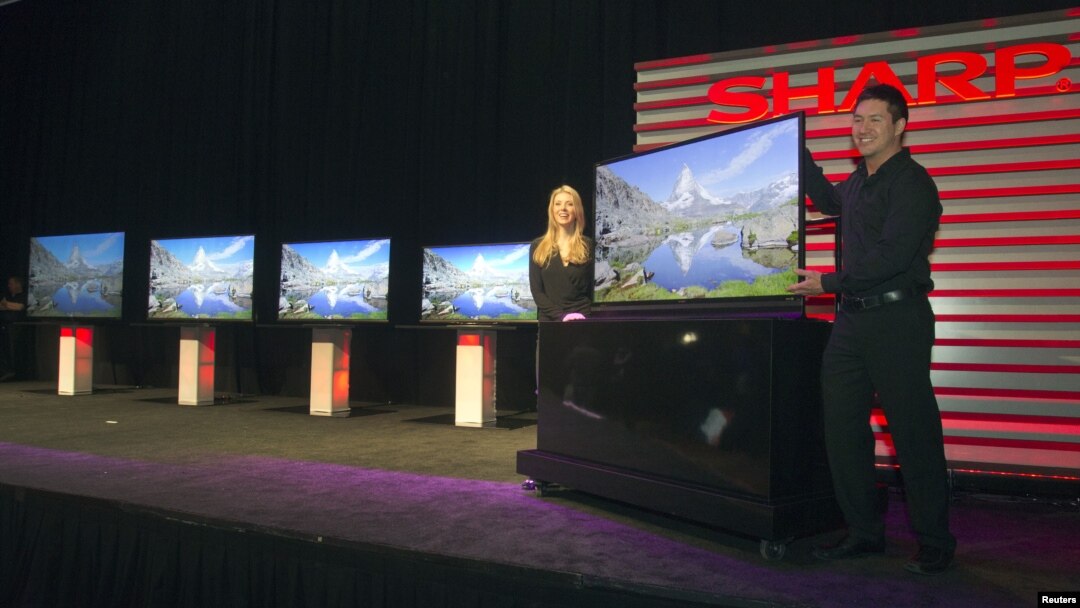 Models stand by a ICC Purios Ultra HD television at a Sharp news conference during the Consumer Electronics Show (CES) in Las Vegas January 7, 2013. Seen in the background are new Aquos 8-Series televisions and a 90-inch LED Smart 3D TV (far left). Sharp 