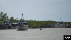 Myanmar navy ships are seen near Hainggyi Island, where a boat crammed with more than 700 migrants was taken, May 30, 2015. 