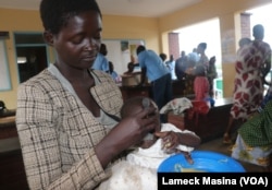 A mother feeds her child supplementary food at Mfera Health Centre in Chikwawa district in Malawi on Oct. 2, 2024.