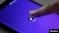 The logo of the TikTok application is seen on a mobile phone screen.