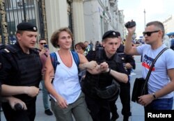 FILE - Law enforcement officers detain a local Reuters journalist during an opposition rally, in Moscow, Russia, July 27, 2019.