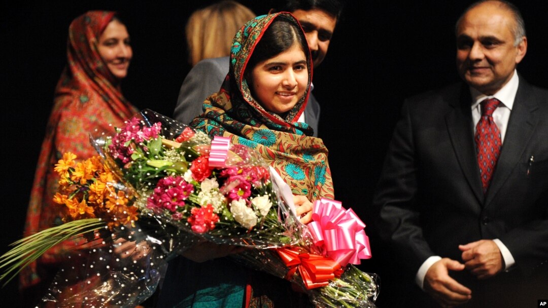 Malala Yousafzai menerima karangan bunga setelah berbicara kepada media di Birmingham, Inggris pasca pengumuman hadiah Nobel Perdamaian 2014, Jumat (10/10).