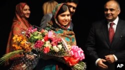 Malala Yousafzai menerima karangan bunga setelah berbicara kepada media di Birmingham, Inggris pasca pengumuman hadiah Nobel Perdamaian 2014, Jumat (10/10).