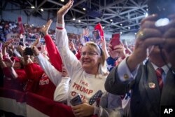Members of the audience wave and cheer as President Donald Trump speaks at a rally at BancorpSouth Arena in Tupelo, Miss., Nov. 1, 2019.