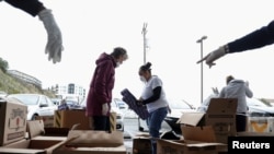 Volunteers sort apples at the San Francisco-Marin Food Bank, amid the novel coronavirus outbreak, in San Francisco, California, March 16, 2020.