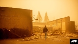 California Governor Gavin Newsom surveys a burned United States Post Office in downtown Greenville, California, Aug. 7, 2021.