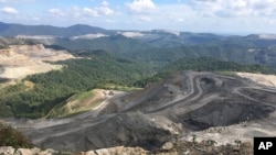 FILE - Coal trucks and heavy equipment look like children's toys on the Middle Ridge surface coal mine in southern West Virginia, Sept. 26, 2017.