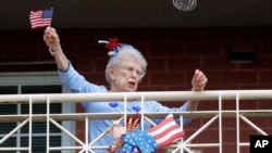 A resident of the Lambeth House, where a cluster of the coronavirus has formed, reacts from her balcony as opera singers Irini Hymel and Bryan Hymel sing to the quarantined residents in New Orleans, March 20, 2020.