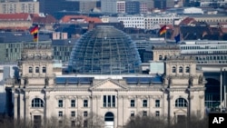 A European and German flags wave at the Reichstag building, the house of German parliament Bundestag at the eve of the national election in Berlin, Feb. 22, 2025.