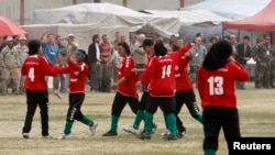 FILE - The Afghan national women's soccer team celebrates a victory in a friendly match against a women's team from the NATO-led International Security Assistance Force in Kabul, Oct. 29, 2010.