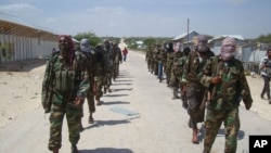  FILE - Members of Somalia's al-Shabab militant group patrol on the outskirts of Mogadishu, March, 5, 2012. 