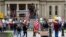 Protesters rally at the State Capitol in Lansing, Mich, April 30, 2020. Gun-carrying protesters have been a common sight at some demonstrations calling for coronavirus-related restrictions to be lifted. 