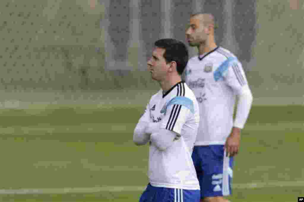 Argentina's Lionel Messi, left, and Javier Mascherano walk during a training session in Vespesiano, near Belo Horizonte, Brazil, Thursday, July 10, 2014. On Sunday, Argentina faces Germany for the World Cup final soccer match in Rio de Janeiro. (AP Photo/