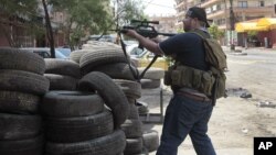 A Sunni gunman fires his weapon during clashes on Syria Street which divided the areas between Sunnis and Alawites, in the northern port city of Tripoli, Lebanon, May 13, 2012. 