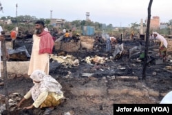 Rohingya refugees pick through what remains after a fire broke out at a camp in Delhi in 2021. Around 50 shanties were reduced to ashes by the fire. Many Rohingya believe that right-wing Hindu groups who want the refugee community to be thrown out of India set fire to the camp.