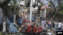 People gather at the scene of an explosion outside a restaurant in Mogadishu, March 28, 2019.