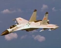 FILE - A Chinese J-11 fighter jet is seen flying about 215 km (135 miles) east of China's Hainan Island in this U.S. Department of Defense handout photo taken Aug. 19, 2014.
