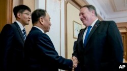 Mike Pompeo cumprimenta Kim Yong Chol. 