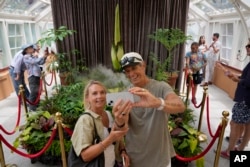 Karen, en el centro a la izquierda, y Wayne McKay se fotografían con una planta en peligro de extinción conocida como "flor cadáver" por su hedor pútrido, en los Jardines Botánicos Reales de Sídney, Australia, el jueves 23 de enero de 2025.