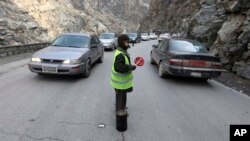 Sedaqat, 11, signals vehicles on the Maipur Pass, along the main highway from Kabul to Pakistan, near Kabul, Afghanistan, Jan. 5, 2017.