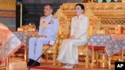 n this Thursday, May 2, 2019, photo released by Bureau of the Thailand Royal Household, Thailand's King Maha Vajiralongkorn, left, and Queen Suthida sit at Bangkok City Pollar Shrine in Bangkok, Thailand. 