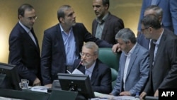 FILE - Iranian Parliament Speaker Ali Larijani (C), surrounded by lawmakers, speaks during a session in the capital Tehran, Aug. 28, 2018.