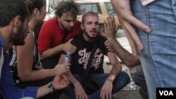 A man is consoled after seeing the tents of hunger protestors destroyed by a self-identified group supporting Lebanese government Speaker and Amal party leader Nabih Berri, Sept. 16, 2015. (J. Owens/VOA)