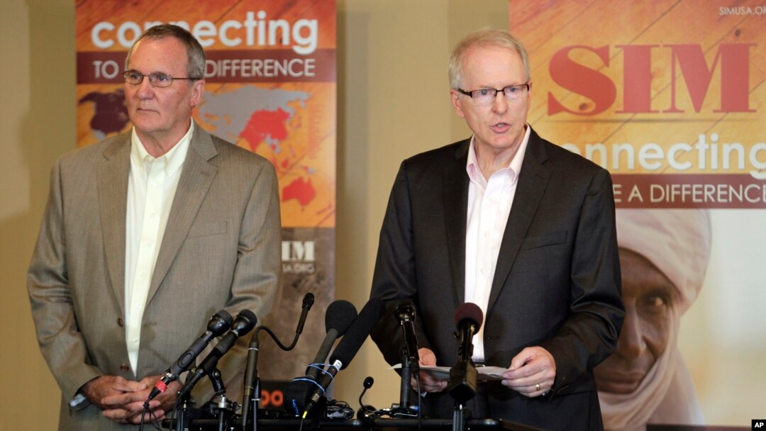 Will Elphick, left, director of Liberia for SIM, USA listens as SIM President Bruce Johnson speaks at a news conference in Charlotte, N.C., Wednesday, Sept., 3, 2014.
