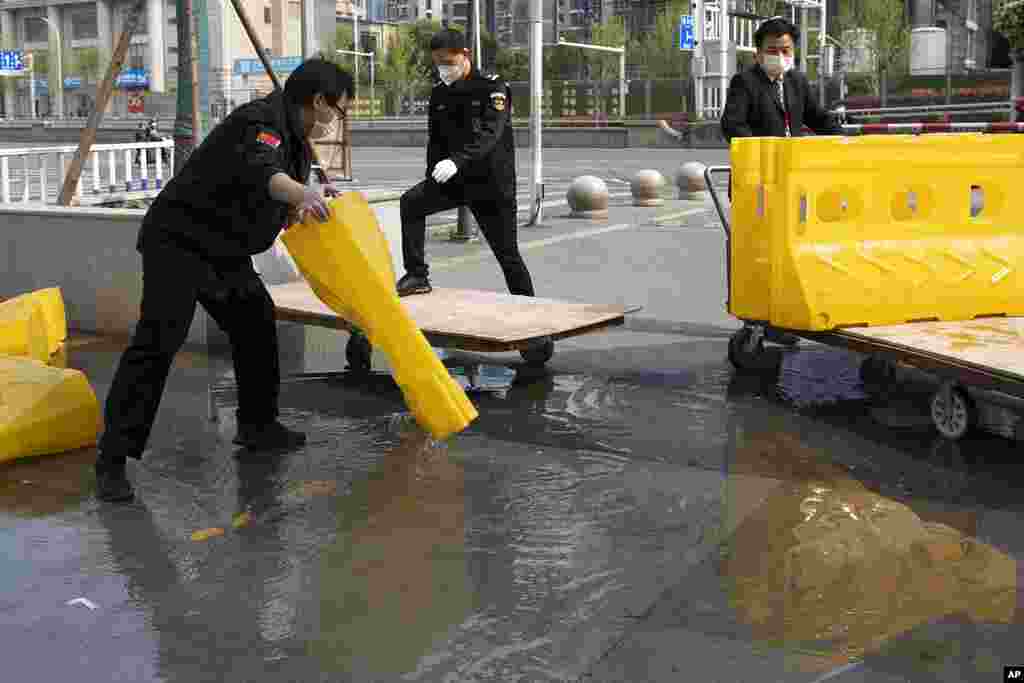 Los trabajadores drenan el agua en las carreteras cercanas a la estación de ferrocarril de Hankou en la víspera de la reanudación del tráfico saliente en Wuhan, el 7 de abril.