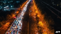 Thousands of cyclists, at right, throng a highway on the Zhengkai Road in Zhengzhou, in northern China's Henan province, Nov. 9, 2024.