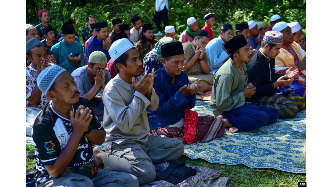 Community members pray in front of a mass grave for victims of the Tak Bai Massacre at a cemetery in Thailand's southern province of Narathiwat on Oct. 25, 2024, on the 20th anniversary of the deaths.