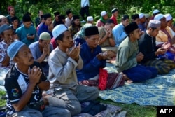 Community members pray in front of a mass grave for victims of the Tak Bai Massacre at a cemetery in Thailand's southern province of Narathiwat on Oct. 25, 2024, on the 20th anniversary of the deaths.