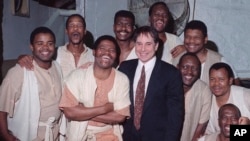 FILE - In this March 1993 file photo, Joseph Shabalala, front left, founder of South Africa's Ladysmith Black Mambazo, stands with the group and Paul Simon, front right, as they pose for a photograph.