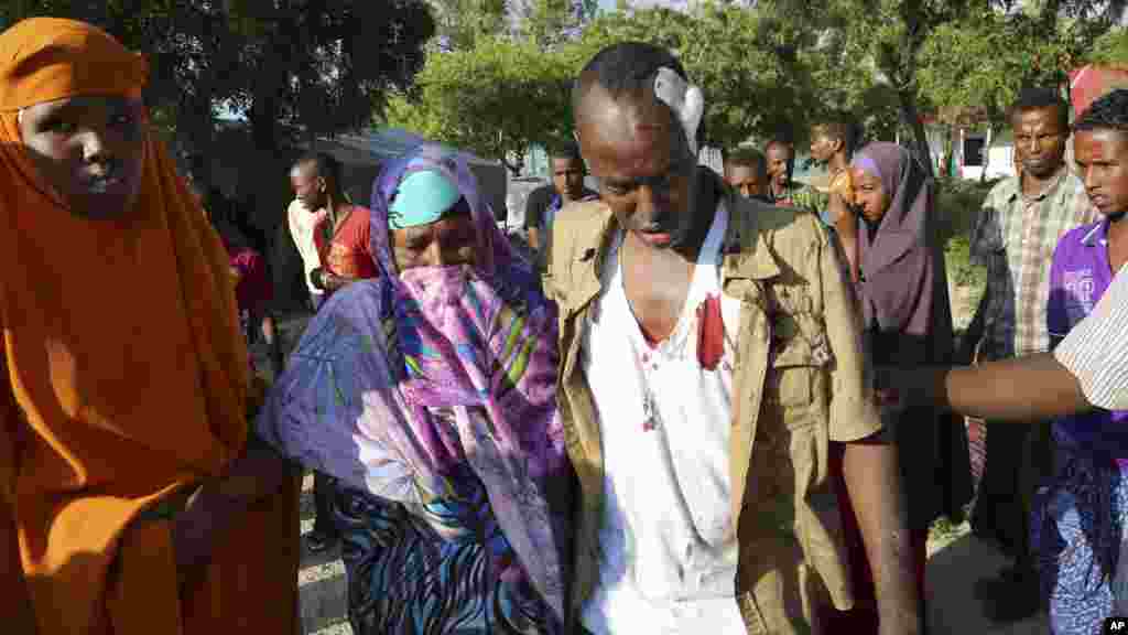 Reuters photographer Feisal Omar, center, who was injured in an explosion, is comforted by family members at the Medina Hospital in Mogadishu, Somalia, Nov. 1, 2015.