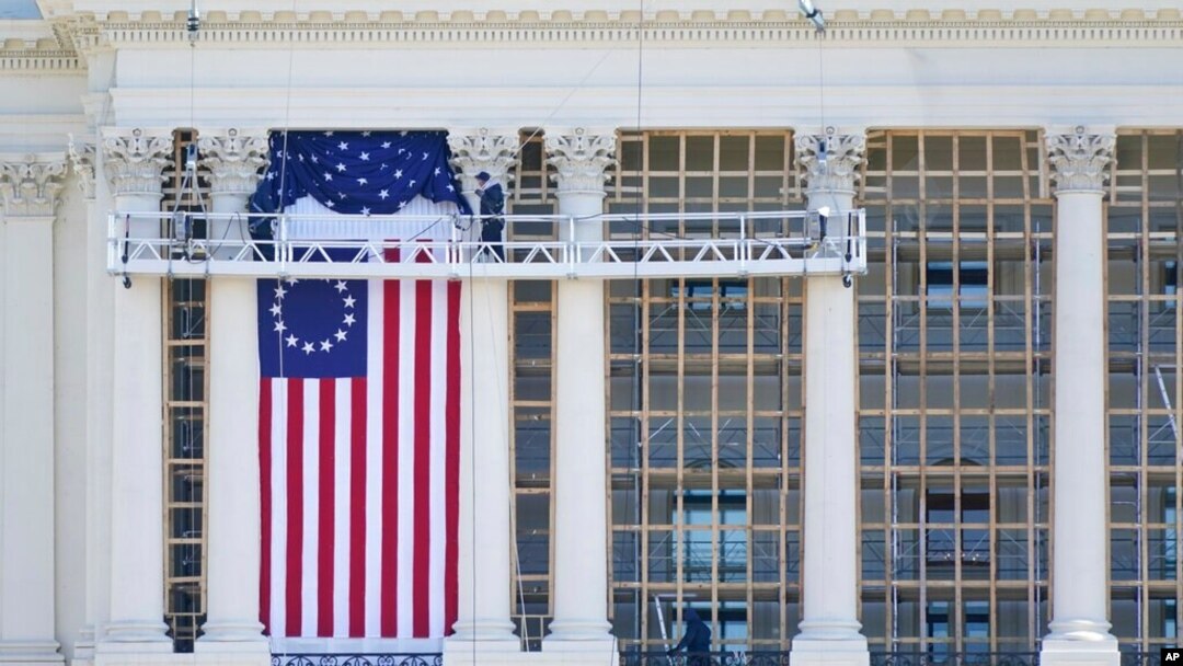 Para pekerja memasang bendera di bagian West Front Gedung Kongres AS sebagai persiapan upacara pelantikan Presiden terpilih Joe Biden, Sabtu, 9 Januari 2021. 
