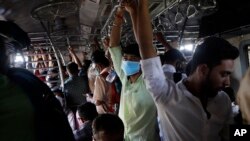 20일 인도 뭄바이에서 마스크를 착용한 채 시민들이 기차로 출근하고 있다. 