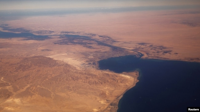 FILE - The Suez Canal connecting the Mediterranean Sea to the Red Sea is pictured from the window of a commercial plane flying over Egypt.