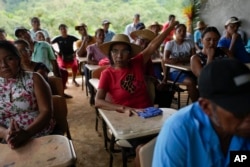 Jeronima Figueroa raises her manus  during a gathering  with Panama Canal representatives astir  a projected  task  that would dam the Indio River and bounds  entree  successful  her assemblage  of El Jobo, Panama, Aug. 31, 2024.