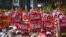 Anti-coup protesters hold up signs calling on others to join the CDM (Civil Disobedience Movement) during a rally near the Mandalay Railway Station in Mandalay, Myanmar, Feb. 22, 2021.