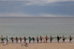 Youths prepare to enter the ocean at Bondi Beach in Sydney, Nov. 23, 2020.